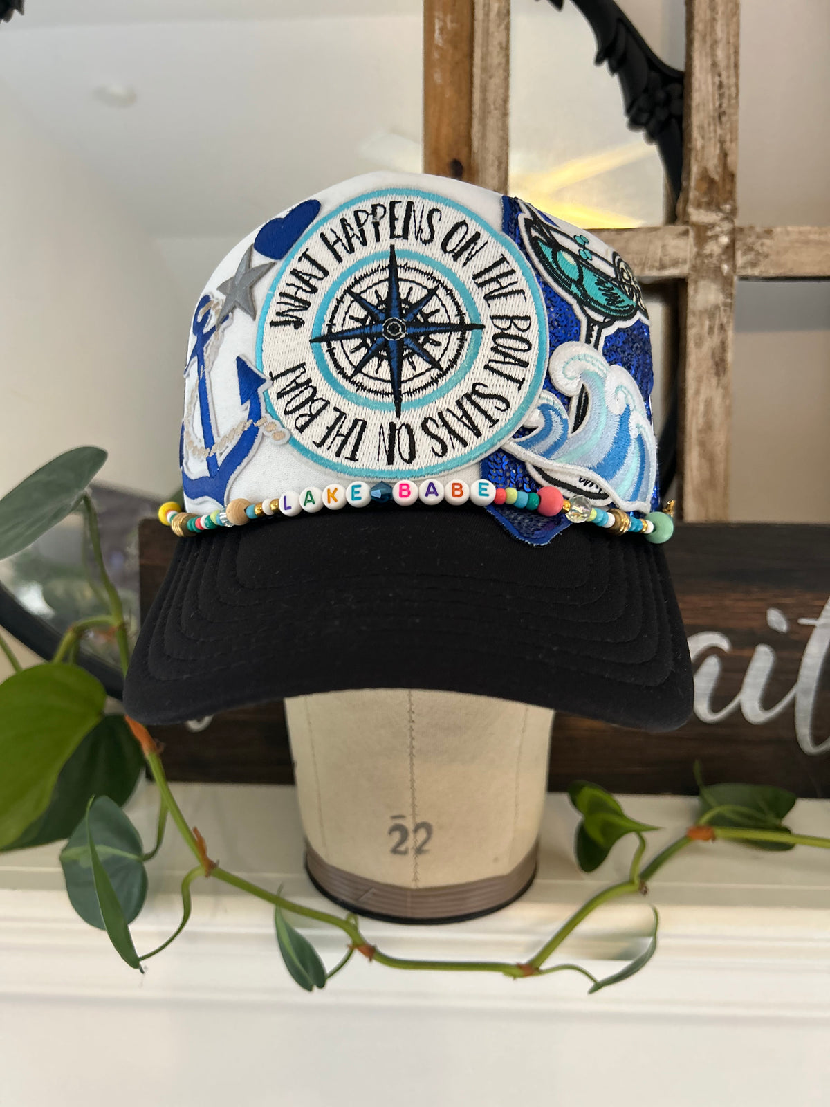 black and white trucker hat with compass, martini, wave, large star, and anchor iron patch 