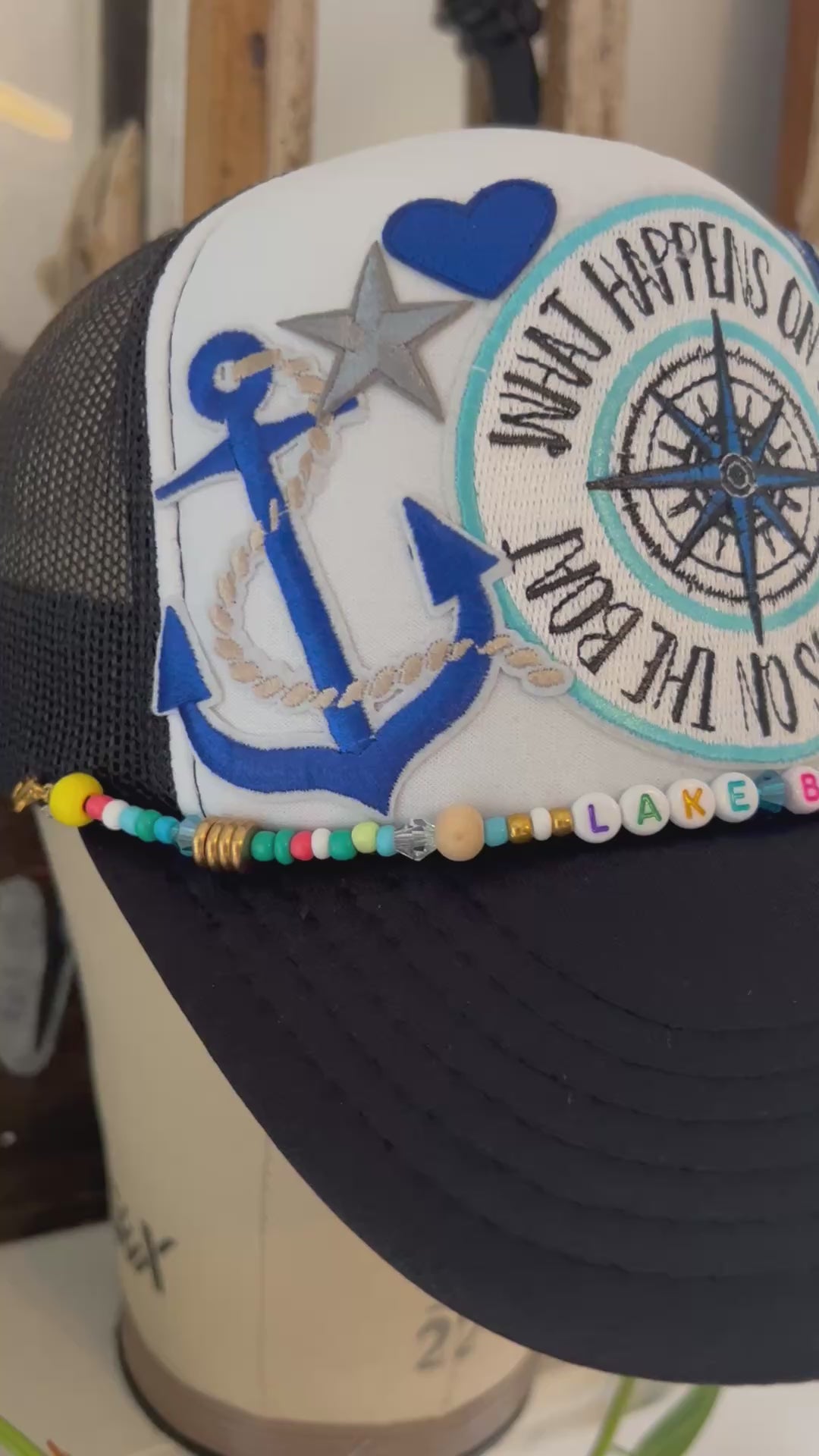 black and white trucker hat with compass, martini, wave, large star, and anchor iron patch 